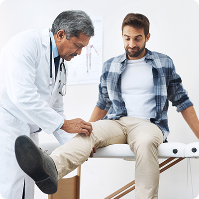 Male doctor examining male patient's leg